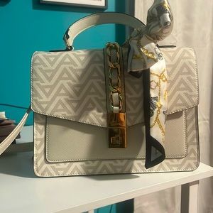 Never used, cream, white and gold colored purse with a ribbon on the handle